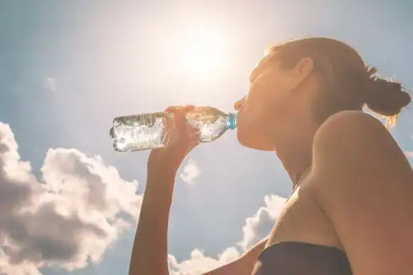 Image of woman drinking water to hydrate Portsmouth  after run.