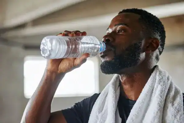 Image of man drinking water to improve hydration Portsmouth  after work out.